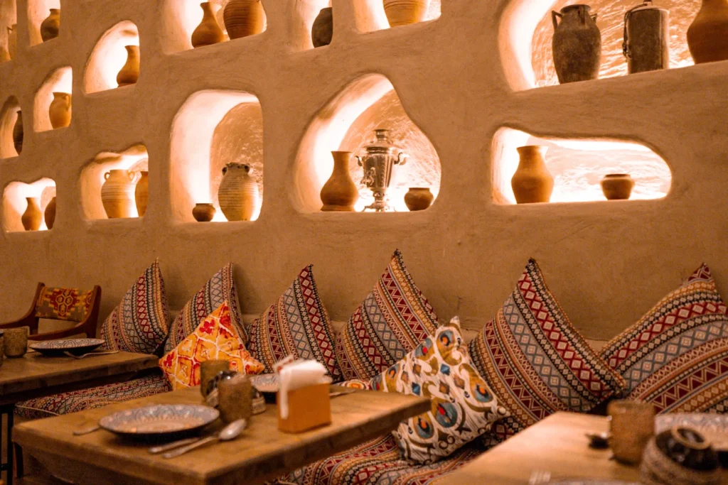 O’ymali daraxtli stol, yumush qopqollar va o’zbek restorani samovar