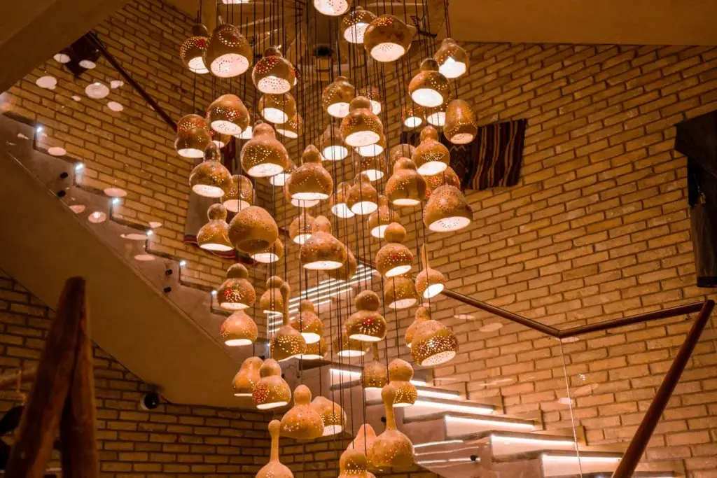 Qo’rg’oshin devorli va qovoq shaklidagi sovuq qo’llangan chiroqlar bilan bezatilgan do’stona restoran