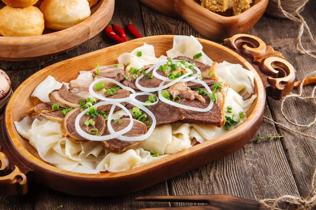 Бешбармак стоит на красочном, накрытом столе