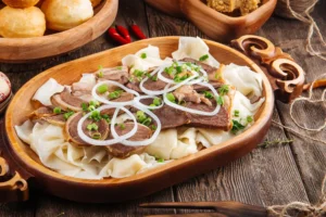 Бешбармак стоит на красочном, накрытом столе