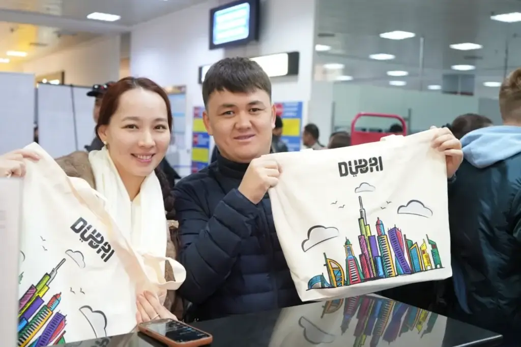 Souvenir tote bags with a Dubai cityscape held by smiling travelers at the airport