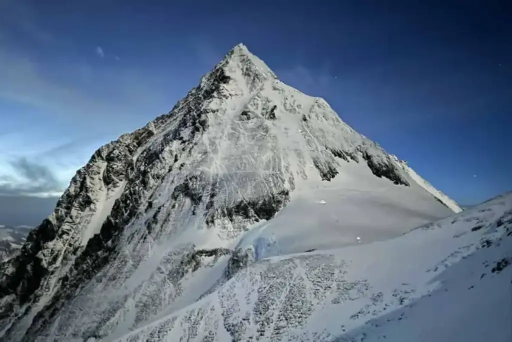 A snow-covered mountain peak against a clear blue sky, showcasing the power and beauty of nature