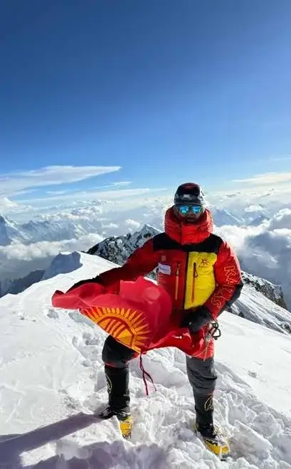 Лыжник на горном склоне с флагом Кыргызстана