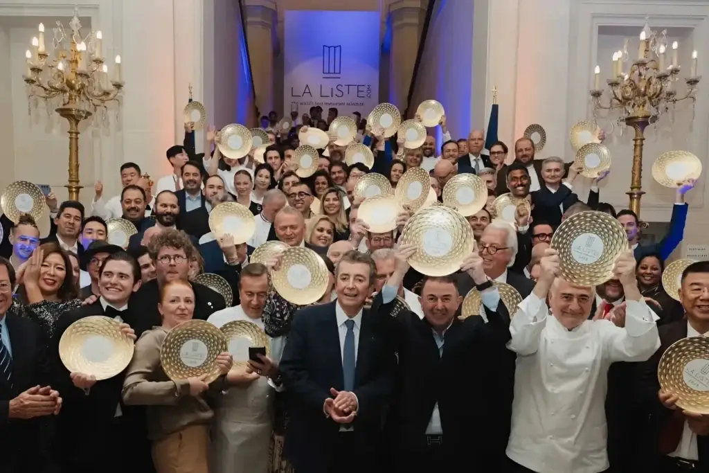 LA LISTE 2025 Award ceremony: a group of people with golden award plates in a luxurious hall with chandeliers.