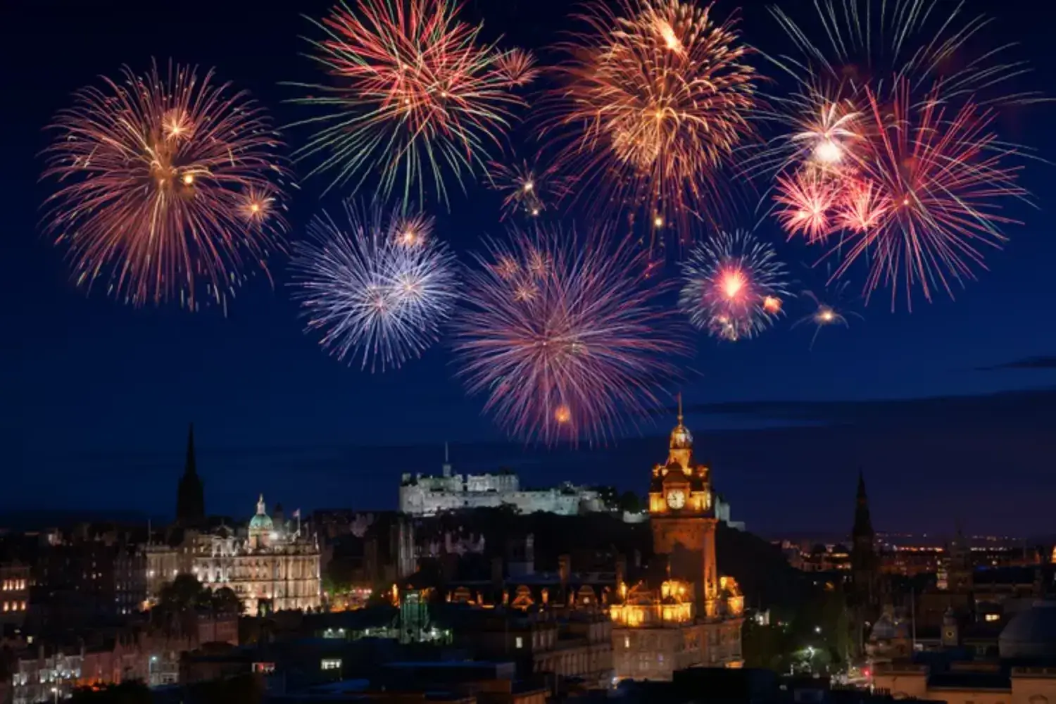 Фейерверки освещают небо над Эдинбургом, Шотландия, в канун Нового года