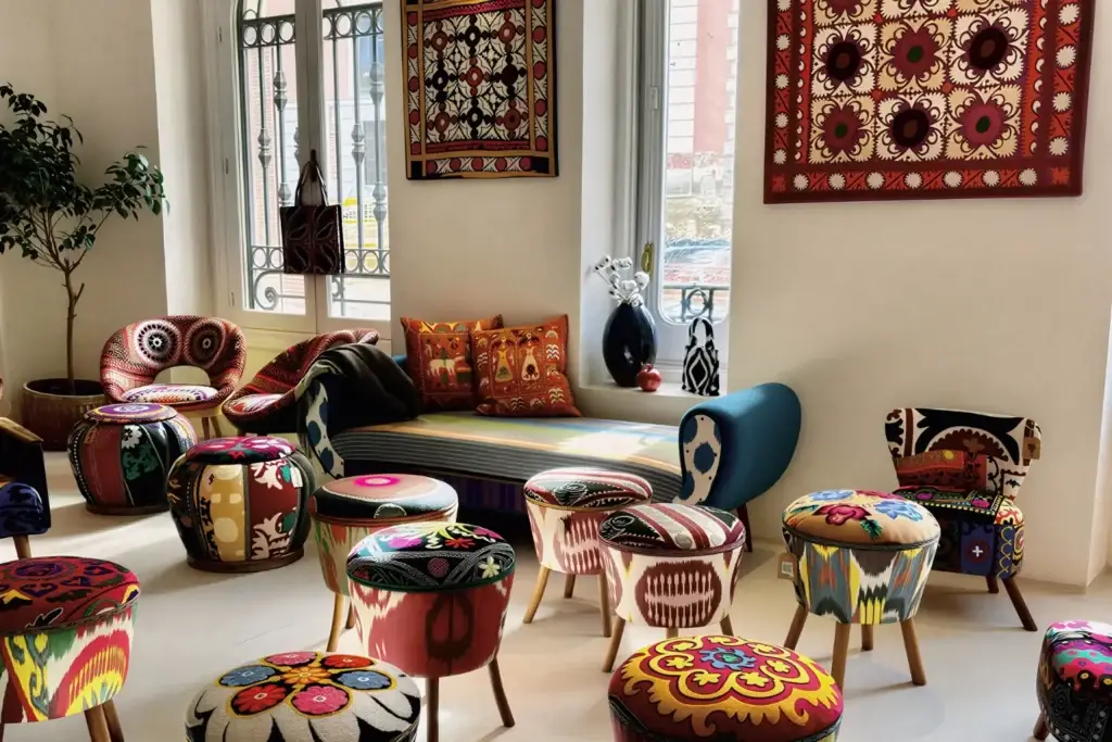 Living room featuring Suzani furniture: poufs, armchairs, sofa with ethnic patterns, decorative wall panels