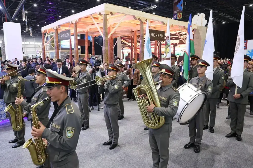 Military band performing in front of the «KHOREZM» stand with flags