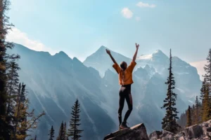 The girl throws up her arms against the background of the mountains