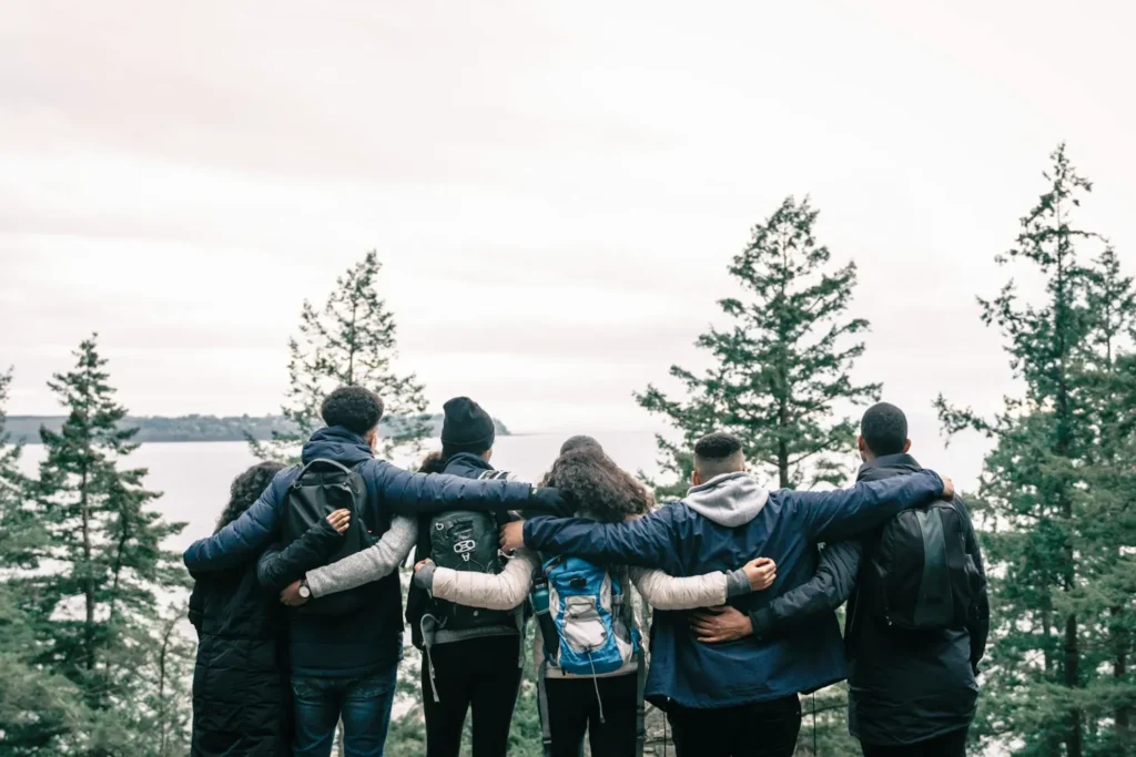 Friends hug against the backdrop of virgin nature