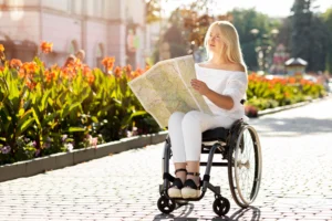 A girl in a wheelchair rides with a map next to flowers
