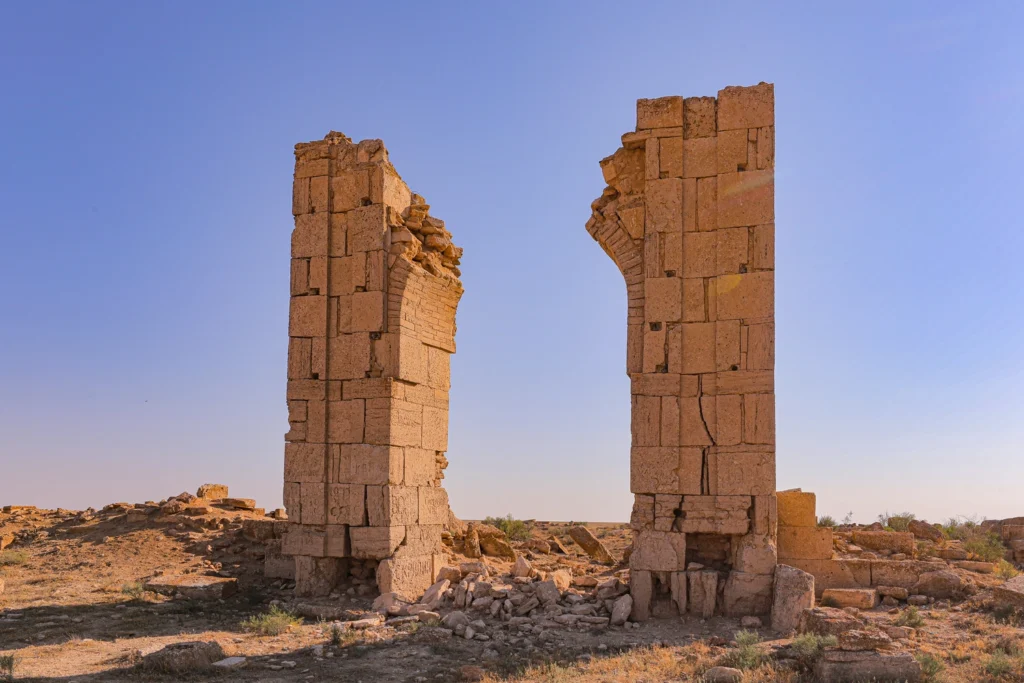 Ruins of two tall stone columns of the Beluli caravanserai on the Ustyurt Plateau in Uzbekistan