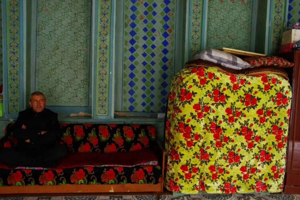 A man surrounded by an old-fashioned interior with traditional paintings